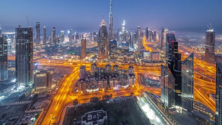 Photo for Aerial panorama of tallest towers in Dubai Downtown skyline night to day transition timelapse before sunrise. Financial district and business area in smart urban city. Skyscraper and high-rise buildings - Royalty Free Image