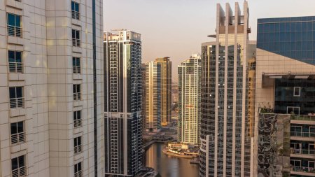 Téléchargez les photos : De grands bâtiments résidentiels dans le quartier JLT matin aérien timelapse pendant le lever du soleil, qui fait partie du centre multi-produits Dubaï quartier à usage mixte. Gratte-ciel avec de longues ombres - en image libre de droit
