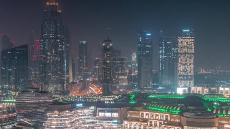 Photo for Aerial view of Dubai International Financial Centre DIFC district during all night . Office towers and hotels with modern skyscrapers and shopping mall with lights turning off - Royalty Free Image