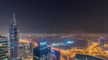 Foto de Aerial skyline with Golf Club, hotels and residential areas far away in desert in Dubai during all night  with fog, UAE, top view from Dubai marina skyscrapers. Lights turning off - Imagen libre de derechos