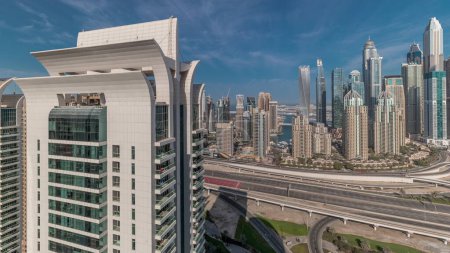 Téléchargez les photos : Panorama showing Dubai Marina and media city with golf course highway intersection spaghetti junction . Tallest skyscrapers and traffic. Aerial top view from JLT district - en image libre de droit