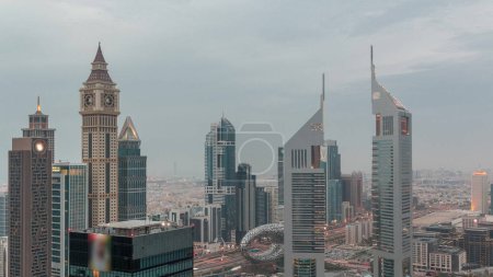Photo for Skyscrapers on Sheikh Zayed Road and DIFC day to night transition  in Dubai, UAE. Towers in financial centre aerial view from above. Cloudy sky after sunset - Royalty Free Image
