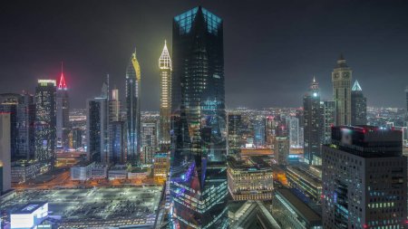 Photo for Panorama showing futuristic skyscrapers in financial district business center in Dubai on Sheikh Zayed road night . Aerial view from above with illuminated towers - Royalty Free Image