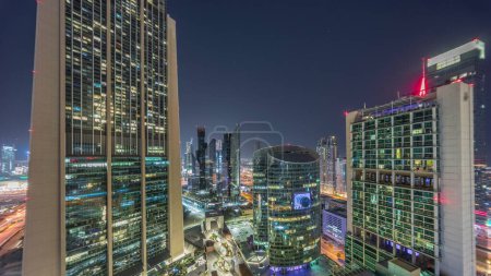 Foto de Dubai international financial center skyscrapers panorama aerial during all night . Illuminated towers view from above with light turning off - Imagen libre de derechos