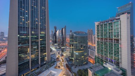 Photo for Dubai international financial center skyscrapers aerial night to day transition panoramic . Illuminated towers view from above before sunrise - Royalty Free Image