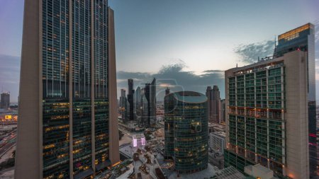 Photo for Dubai international financial center skyscrapers aerial day to night transition . Illuminated towers with promenade panoramic view from above after sunset - Royalty Free Image