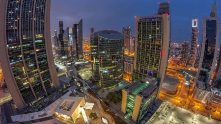 Téléchargez les photos : Panorama of Dubai international financial center skyscrapers aerial night to day transition . Illuminated towers view from above before sunrise - en image libre de droit