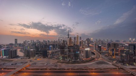 Foto de Panoramic skyline of Dubai with business bay and downtown district and traffic on al khail road day to night . Aerial view of many modern skyscrapers with colorful clouds after sunset. United Arab Emirates. - Imagen libre de derechos