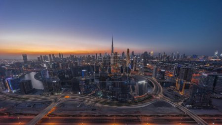 Téléchargez les photos : Panoramic skyline of Dubai with business bay and downtown district day to night . Aerial view of many modern skyscrapers with traffic on al khail road after sunset. United Arab Emirates. - en image libre de droit