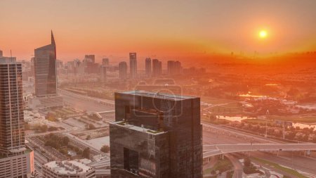 Photo for Sunrise over media city and al barsha heights district aerial  from Dubai marina. Towers and skyscrapers with golf course and traffic on a highway from above - Royalty Free Image