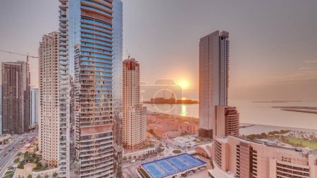 Photo for Panoramic sunset view of the Dubai Marina and JBR area and the famous Ferris Wheel aerial  and golden sand beaches in the Persian Gulf - Royalty Free Image