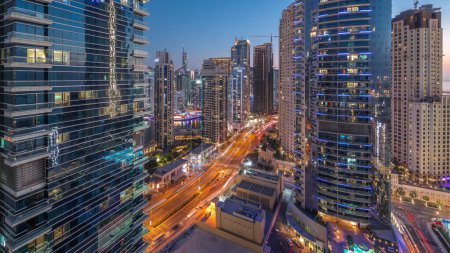 Foto de Panoramic view of the Dubai Marina and JBR area aerial day to night transition . Traffic on the road after sunset - Imagen libre de derechos
