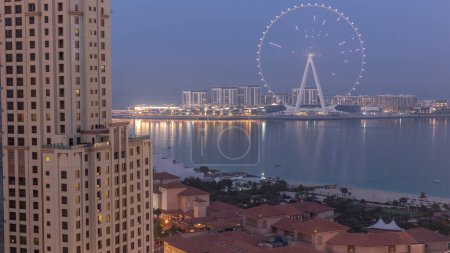 Téléchargez les photos : Bluewaters island with modern architecture and ferris wheel aerial night to day transition . New leisure and residential area near Dubai marina and JBR before sunrise - en image libre de droit
