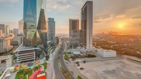 Foto de Sunrise in Dubai International Financial district transition . Panoramic aerial view of business office towers at morning. Skyscrapers with orange cloudy sky - Imagen libre de derechos