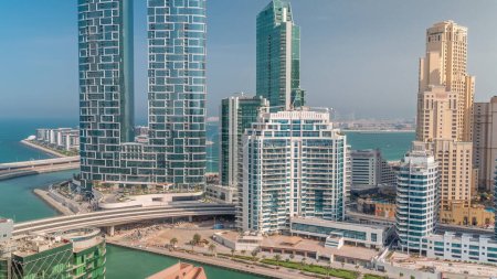 Promenade and canal seen from Dubai marina . Aerial view to JBR district and Bluewaters Island behind with hotels and skyscrapers.
