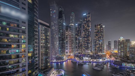 Foto de Panorama showing Dubai marina tallest skyscrapers and yachts in harbor aerial night . View at apartment buildings, hotels and office blocks, modern residential development of UAE - Imagen libre de derechos