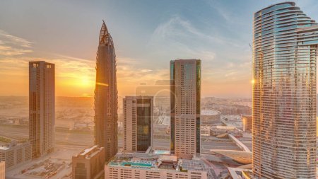 Photo for Sky view to skyscrapers during sunset in Dubai downtown aerial . Modern architecture with orange clouds and traffic on a highway. City walk district on a background - Royalty Free Image