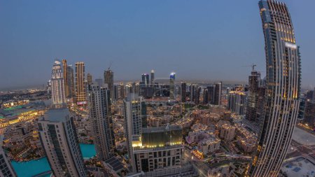 Téléchargez les photos : Aerial panorama of a big futuristic city day to night transition . Business bay and Downtown district with many skyscrapers and traditional houses, Dubai, United Arab Emirates skyline. - en image libre de droit