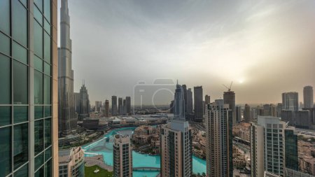 Téléchargez les photos : Dubai downtown during sunrise with fountains and modern futuristic architecture aerial . Panoramic view to skyscrapers with old town and shopping mall - en image libre de droit