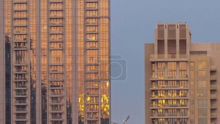 Foto de Two business office skyscrapers at sunset with stunning sun reflections on the teal and orange glass facades, with blue sky - Imagen libre de derechos