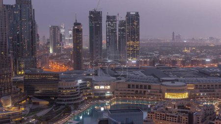 Photo for Dubai downtown with fountains and modern futuristic architecture aerial night to day transition . View to skyscrapers with financial district and shopping mall - Royalty Free Image