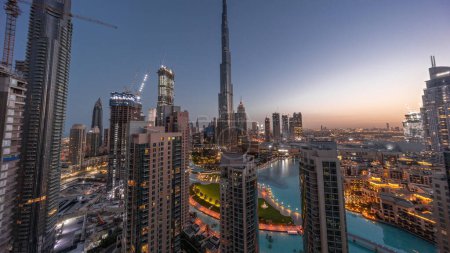 Photo for Dubai Downtown cityscape with tallest skyscrapers around aerial night to day transition panoramic . Construction site of new towers and busy roads with traffic from above - Royalty Free Image