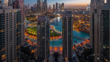 Foto de Dubai Downtown cityscape with tallest skyscrapers around fountain aerial night to day transition . Old town houses and busy roads with traffic from above - Imagen libre de derechos