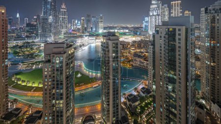 Photo for Panorama showing Dubai Downtown cityscape with tallest skyscrapers around aerial night . Construction site of new towers and busy roads with traffic from above - Royalty Free Image