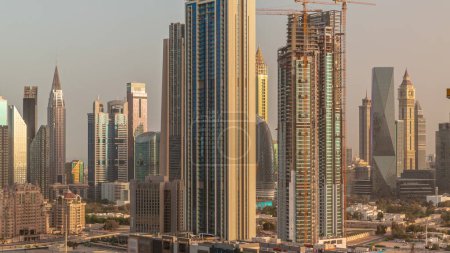 Téléchargez les photos : Row of the tall buildings panorama around Sheikh Zayed Road and DIFC district aerial morning  in Dubai, UAE. International Financial Centre skyscrapers during sunrise - en image libre de droit