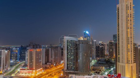 Photo for Skyscrapers at the Business Bay in Dubai aerial day to night transition panoramic . Road intersection and construction site of new towers with cranes after sunset, United Arab Emirates - Royalty Free Image