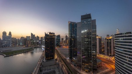 Foto de Cityscape of skyscrapers in Dubai Business Bay with water canal aerial day to night transition . Modern skyline with towers and road traffic after sunset. A center of international business - Imagen libre de derechos