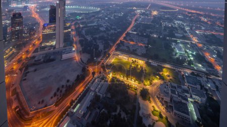 Photo for Villas in Zabeel district with skyscrapers on a background aerial night to day transition  with sunrise in Dubai, UAE. Traffic on streets with illuminated houses and roads - Royalty Free Image