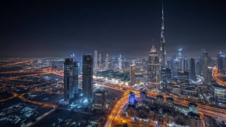 Téléchargez les photos : Panorama showing aerial view of tallest towers in Dubai Downtown skyline and highway night  panorama. Financial district and business area in smart urban city. Skyscraper and high-rise buildings - en image libre de droit