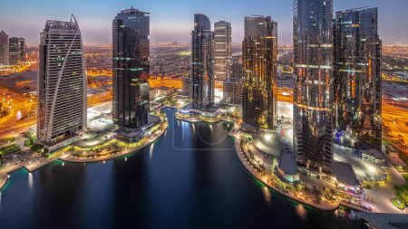 Foto de Tall residential buildings at JLT district aerial night to day transition panoramic , part of the Dubai multi commodities centre mixed-use district. Skyscrapers before sunrise - Imagen libre de derechos