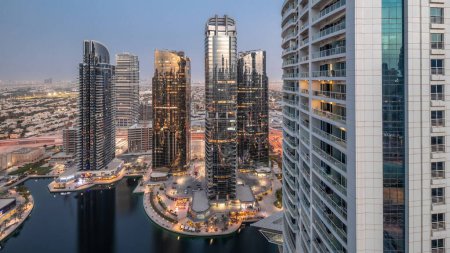 Foto de Tall residential buildings at JLT district aerial day to night transition , part of the Dubai multi commodities centre mixed-use district. Many balconies on towers - Imagen libre de derechos