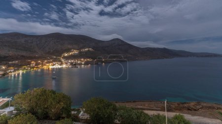 Photo for Panorama of Amorgos island aerial night timelapse from above. Traditional Greece - illuminated white houses on hills and sea harbor, Cyclades - Royalty Free Image