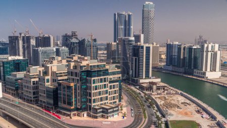 Foto de Timelapse del distrito de Bay Square con uso mixto y edificios de oficinas complejos de poca altura ubicados en Business Bay en Dubai. Vista aérea desde arriba con rascacielos y tráfico en la carretera - Imagen libre de derechos