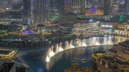Photo for Dubai Fountain aerial night timelapse. Musical fountain, located in an artificial lake in downtown. Top view from above with evening illumination - Royalty Free Image