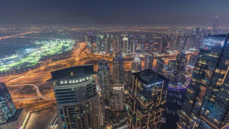 Foto de Panorama de Dubai Marina con rascacielos JLT y campo de golf día a noche timelapse transición, Dubai, Emiratos Árabes Unidos. Vista aérea desde las torres superiores después del atardecer - Imagen libre de derechos