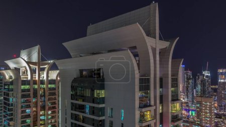 Téléchargez les photos : Vue aérienne des gratte-ciel de la JLT et de la marina de Dubaï avec des fenêtres éclatantes timelapse nocturne avec la circulation sur la route cheikh zayed. Vue de dessus - en image libre de droit