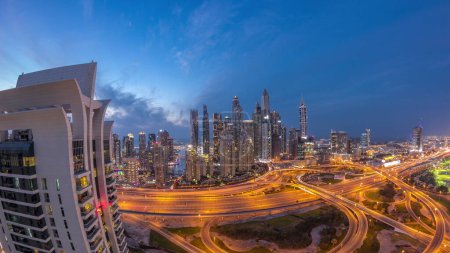 Téléchargez les photos : Panorama de Dubai Marina après le coucher du soleil carrefour de l'autoroute spaghetti jonction jour-nuit timelapse de transition. Les gratte-ciel les plus hauts éclairés sur un fond. Vue aérienne du quartier JLT. - en image libre de droit