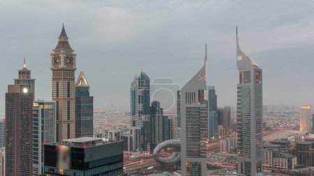 Téléchargez les photos : Des gratte-ciel sur Sheikh Zayed Road et le passage du jour à la nuit du DIFC se déroulent à Dubaï, aux Émirats arabes unis. Tours dans le centre financier vue aérienne d'en haut. Ciel nuageux après le coucher du soleil - en image libre de droit