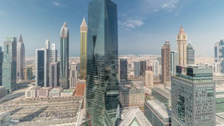 Téléchargez les photos : Panorama montrant de nombreux gratte-ciel futuristes dans le centre d'affaires du quartier financier de Dubaï sur la route Cheikh Zayed timelapse. Vue aérienne d'en haut avec nuages - en image libre de droit