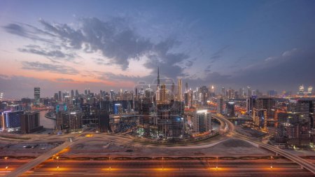 Téléchargez les photos : Skyline panoramique de Dubaï avec la baie d'affaires et le quartier du centre-ville et la circulation sur al khail road night. Vue aérienne de nombreux gratte-ciel modernes avec des nuages colorés après le coucher du soleil. Émirats arabes unis. - en image libre de droit
