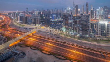 Foto de Skyline panorámico de Dubai con la bahía de negocios y el centro de la noche de distrito con el tráfico en la carretera al khail. Vista aérea de muchos rascacielos modernos y obras de construcción antes del amanecer. Emiratos Árabes Unidos - Imagen libre de derechos