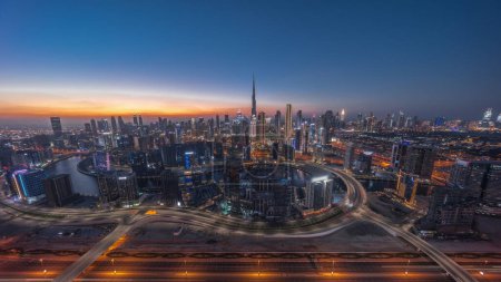 Photo for Panoramic skyline of Dubai with business bay and downtown district day to night timelapse. Aerial view of many modern skyscrapers with traffic on al khail road after sunset. United Arab Emirates. - Royalty Free Image