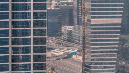 Foto de Vista aérea de cerca de la ciudad de los medios de comunicación y al barsha alturas zona de distrito timelapse de Dubai marina. Vista entre torres y rascacielos con tráfico en un paso elevado desde arriba - Imagen libre de derechos