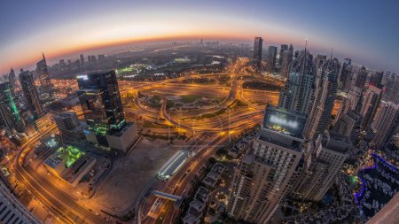 Téléchargez les photos : Marina de Dubaï avec la ville des médias et JLT éclairé gratte-ciel le long de Sheikh Zayed Road nuit aérienne à la transition de jour timelapse panoramique avant le lever du soleil. Immeubles résidentiels et de bureaux d'en haut. - en image libre de droit