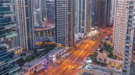 Téléchargez les photos : Vue aérienne sur Dubai Marina éclairé gratte-ciel et yacht dans le port nuit à jour transition timelapse. Tours le long de la zone de marche sur un front de mer. Dubai, Émirats arabes unis - en image libre de droit