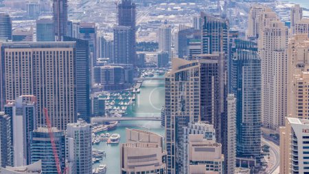 Foto de Vista panorámica de Dubai Marina mostrando un canal artificial rodeado de rascacielos a lo largo de la costa durante todo el día timelapse aéreo con sombras que se mueven rápidamente. Yates y barcos flotantes. DUBAI, Emiratos Árabes Unidos - Imagen libre de derechos